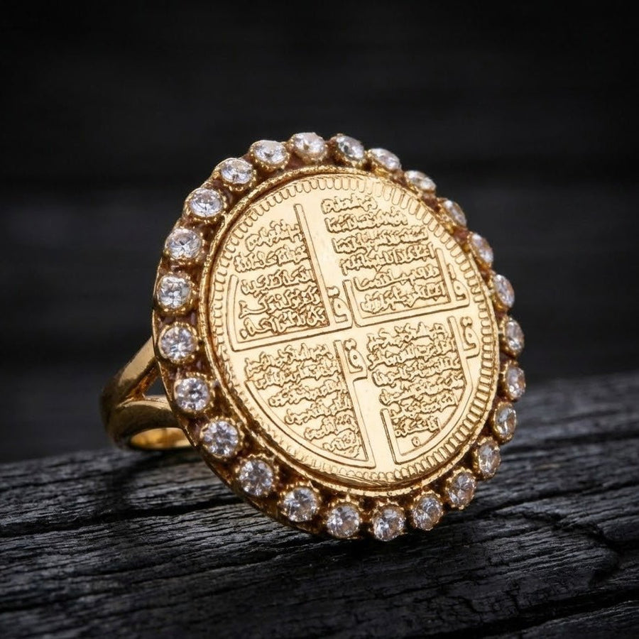 Close-up side angle of gold religious ring featuring detailed Surah engraving and stone accents on dark background
