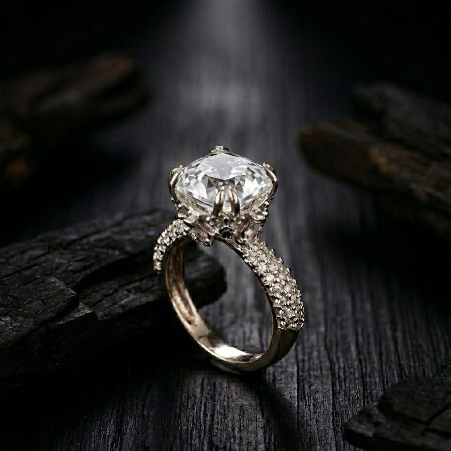 Silver cocktail ring with clear white cushion-cut gemstone and pave-set accent stones on band