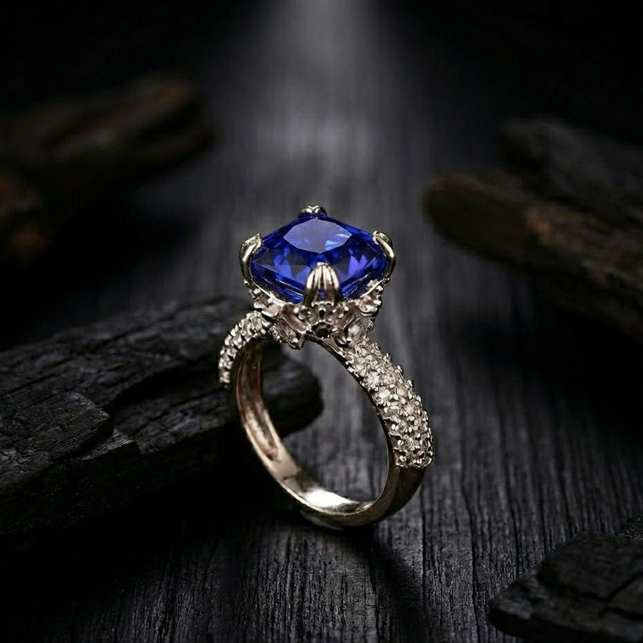 Silver cocktail ring with royal blue cushion-cut gemstone and pave-set accent stones on band