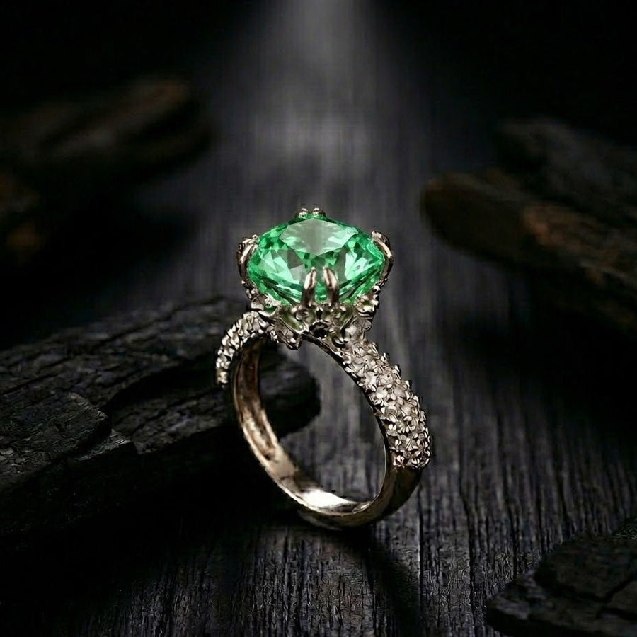 Silver cocktail ring with emerald green cushion-cut gemstone and pave-set accent stones on band