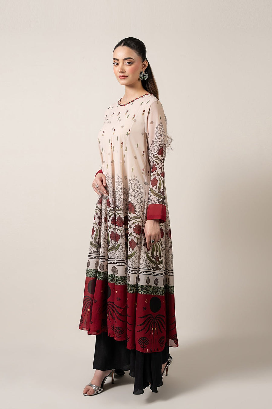 Side view of floral chiffon pishwas dress showing flared hem and intricate print extending to sleeves with maroon cuffs
