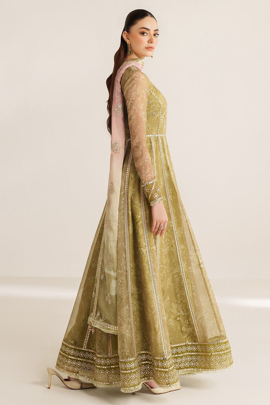 Side view of woman wearing elegant olive green embroidered formal Anarkali dress with sheer lace sleeves and a pink embroidered dupatta