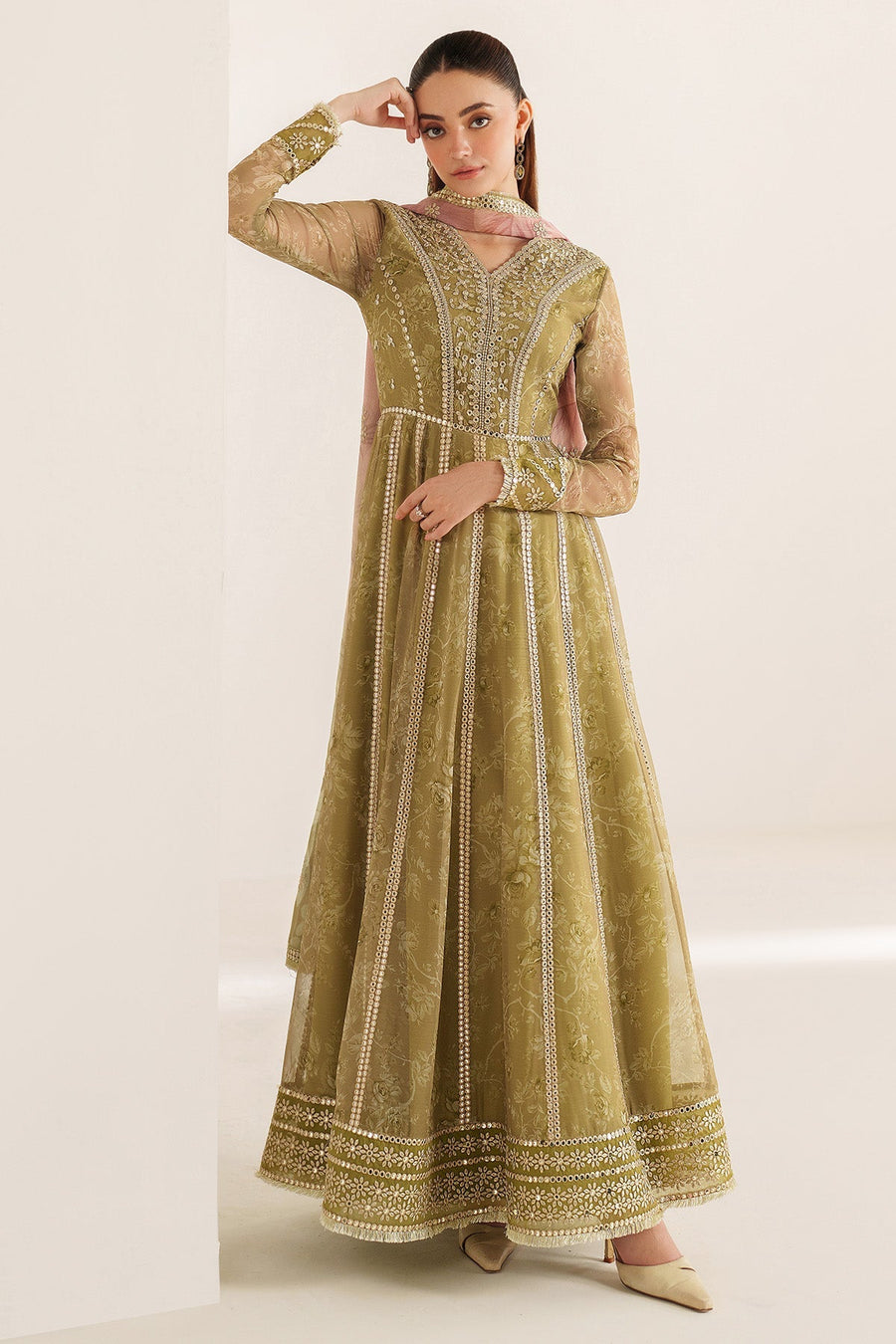 Front view of woman posing in olive green embroidered formal Anarkali dress showcasing sequined detail and full skirt