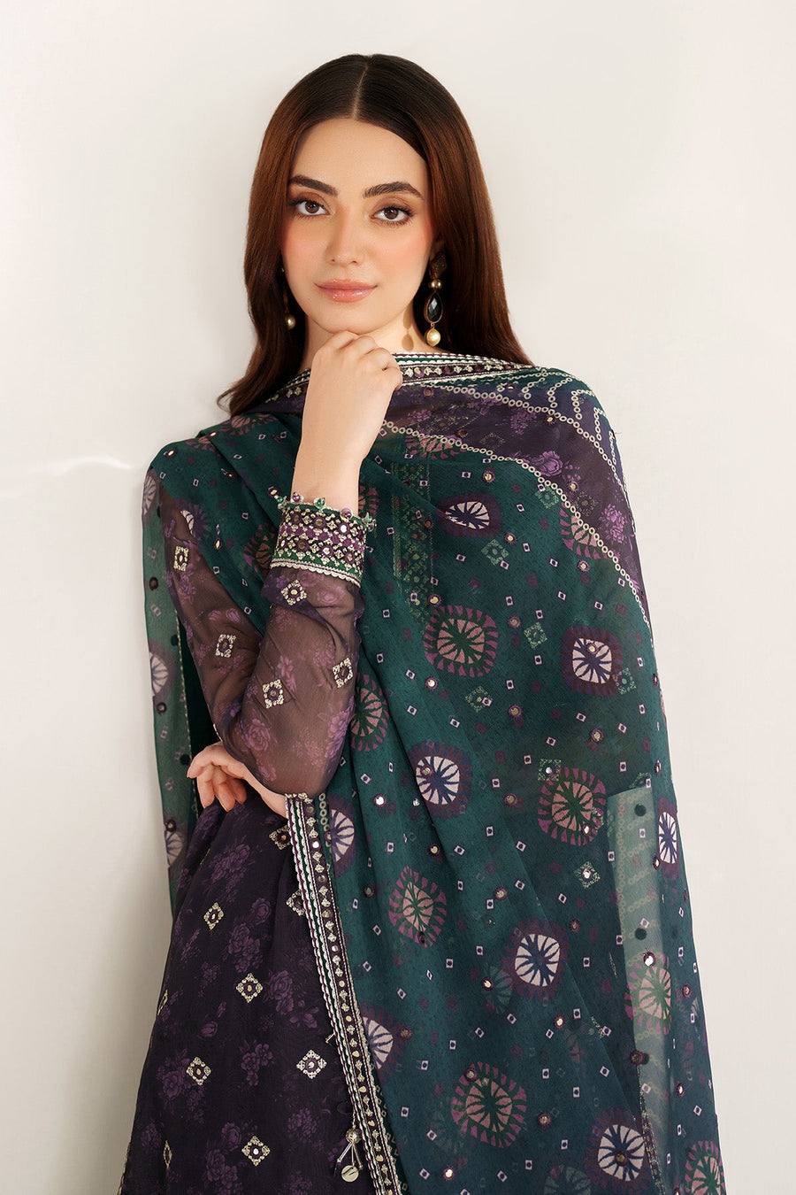 Close-up of neckline and cuff embroidery with mirror embellishments on purple fabric