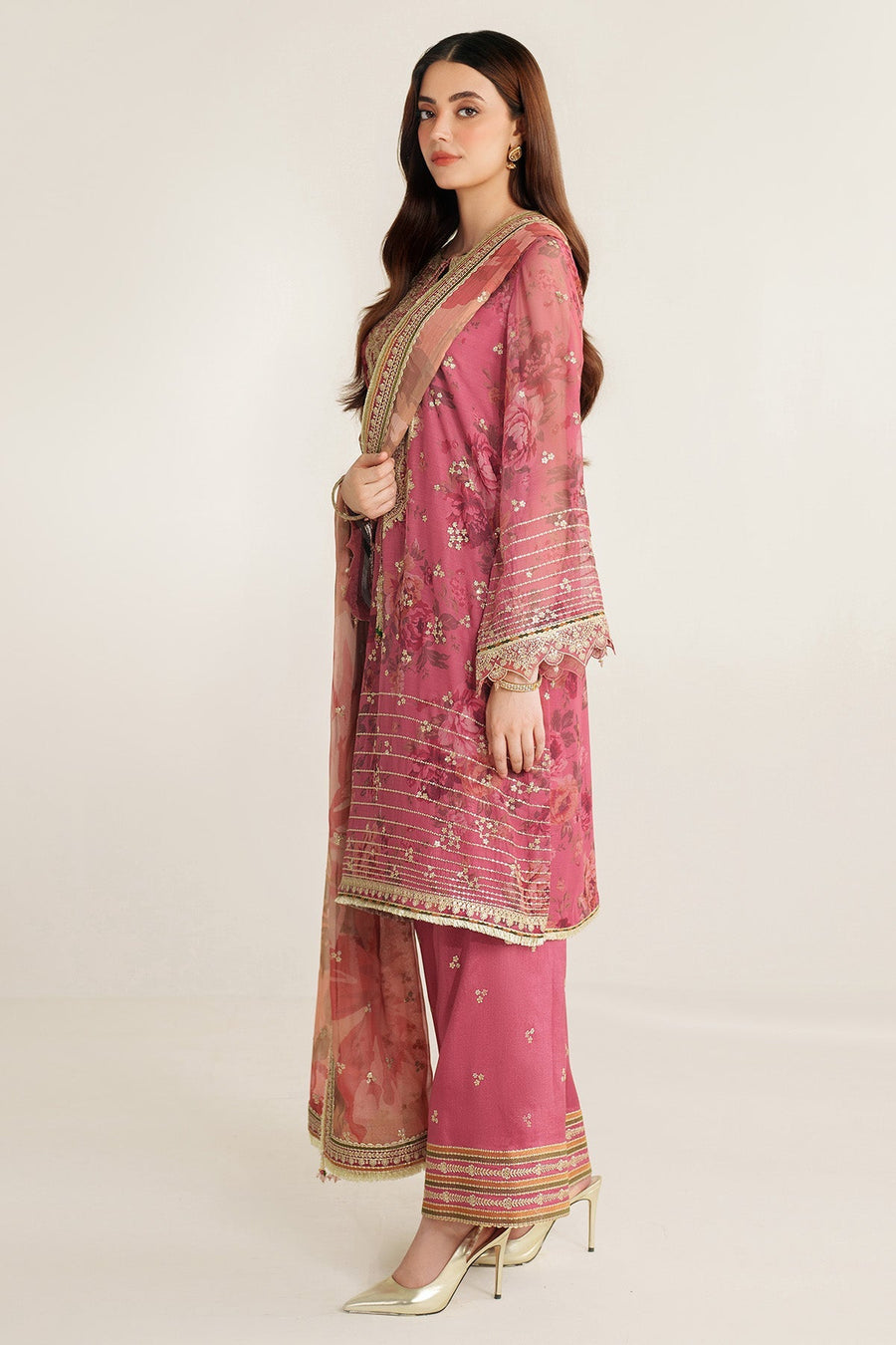 Side profile full-length view of woman dressed in mauve-pink embroidered chavon suit with dupatta and palazzo