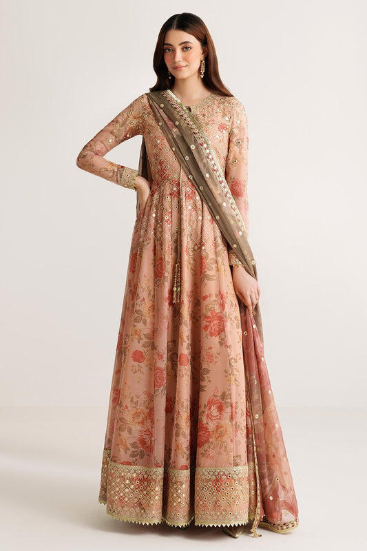 Front view of woman wearing peach floral chiffon Anarkali suit with gold embroidery holding dupatta on shoulder