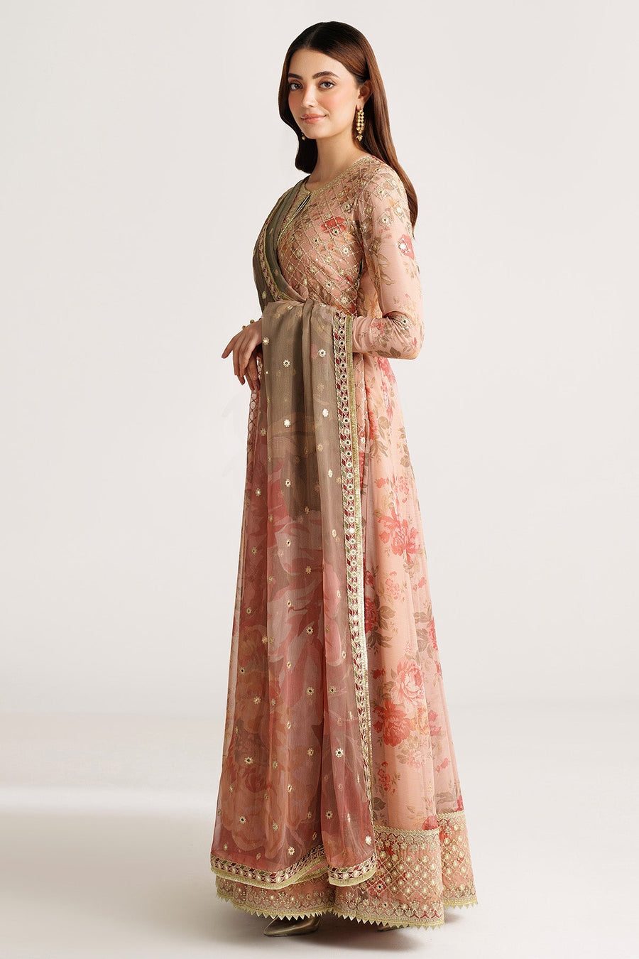 Model holding bouquet of white flowers wearing peach floral embroidered Anarkali suit