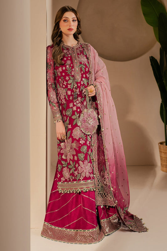 Model wearing a luxurious deep magenta embroidered Pakistani formal suit standing indoors with sheer pink embroidered dupatta