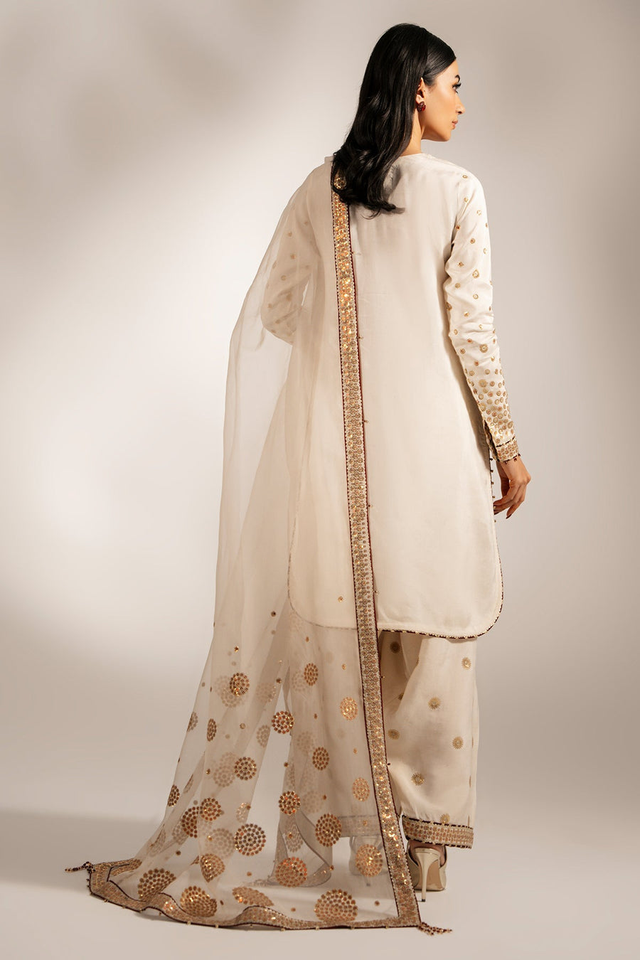 Overall outfit showing the harmony of embellishments on shirt, trousers, and sheer organza dupatta in cream and gold.