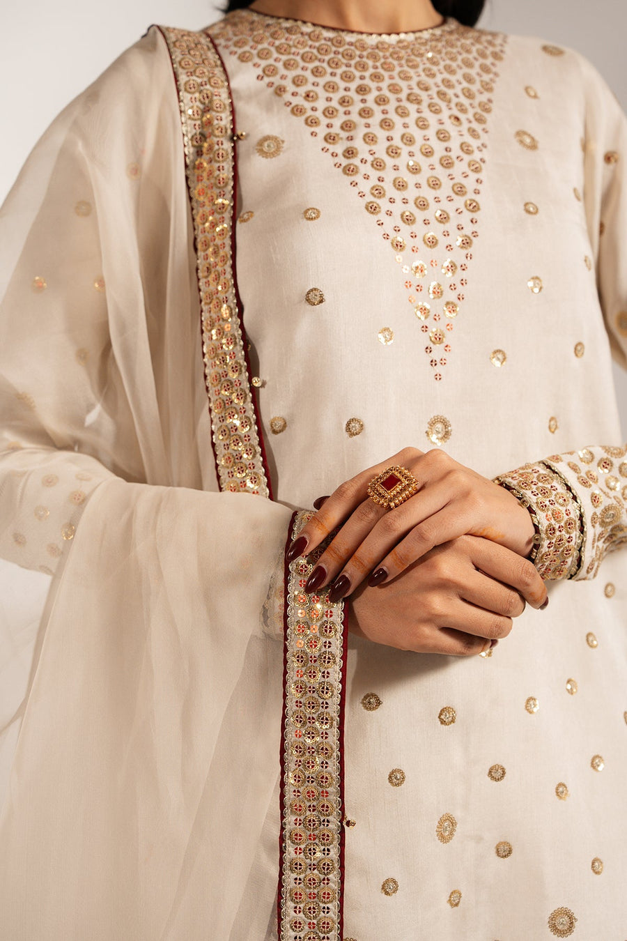 Detailed close-up of the dupatta's embroidered golden circular motifs and decorative border with sequins.