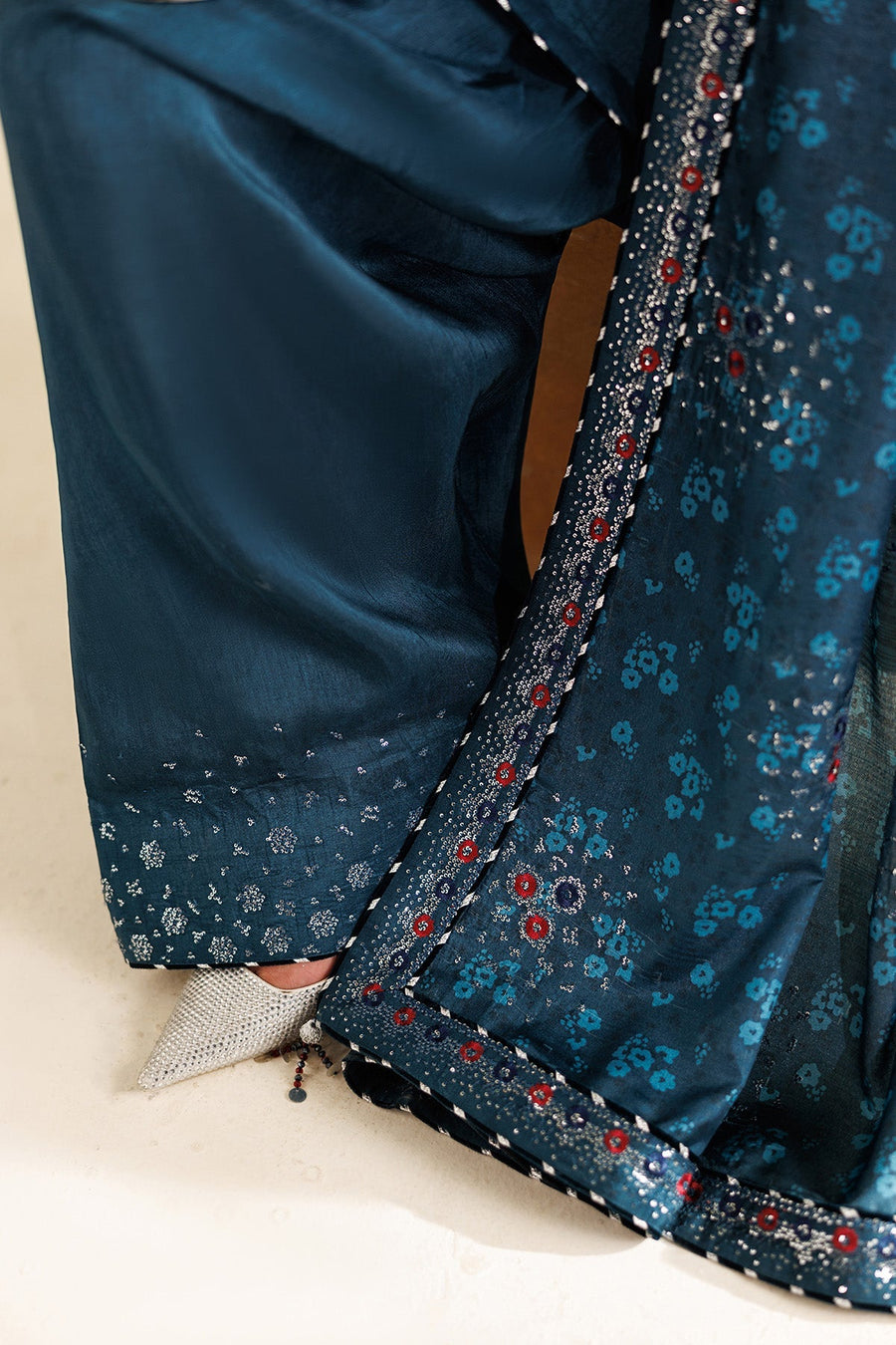 Detailed front view of suit showing multicolored embroidery on neckline and upper sleeves.