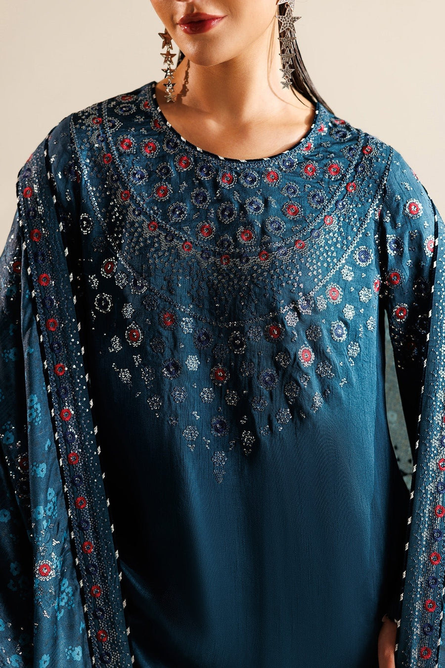 Model posing with printed and embroidered dupatta draped over shoulder showing fabric texture and embroidery.
