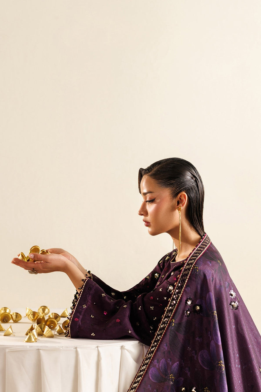 Close-up side angle showing intricate ring and bracelet styling complementing the embroidered suit