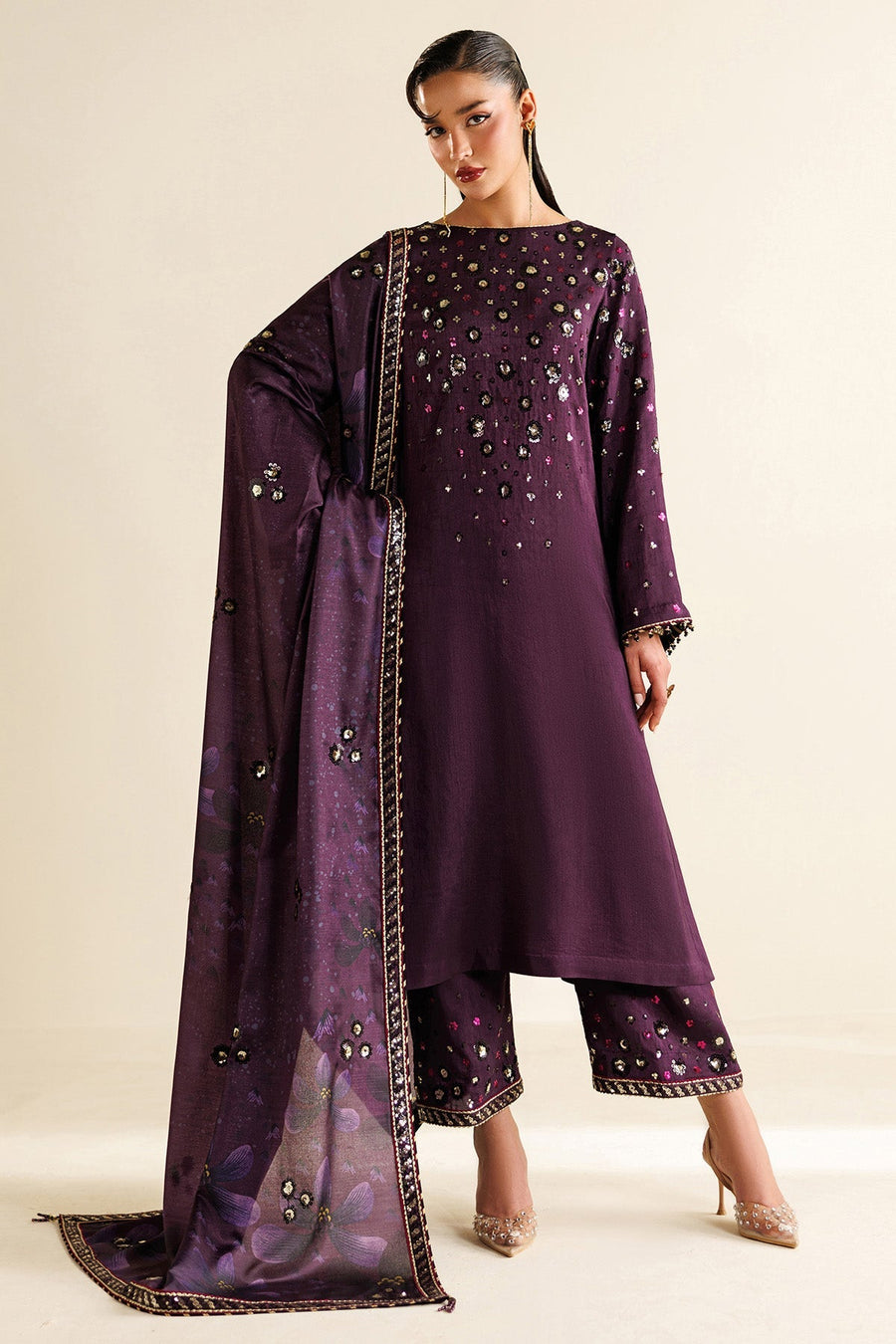Side profile highlighting the embroidery on the trousers and the suit’s elegant fit