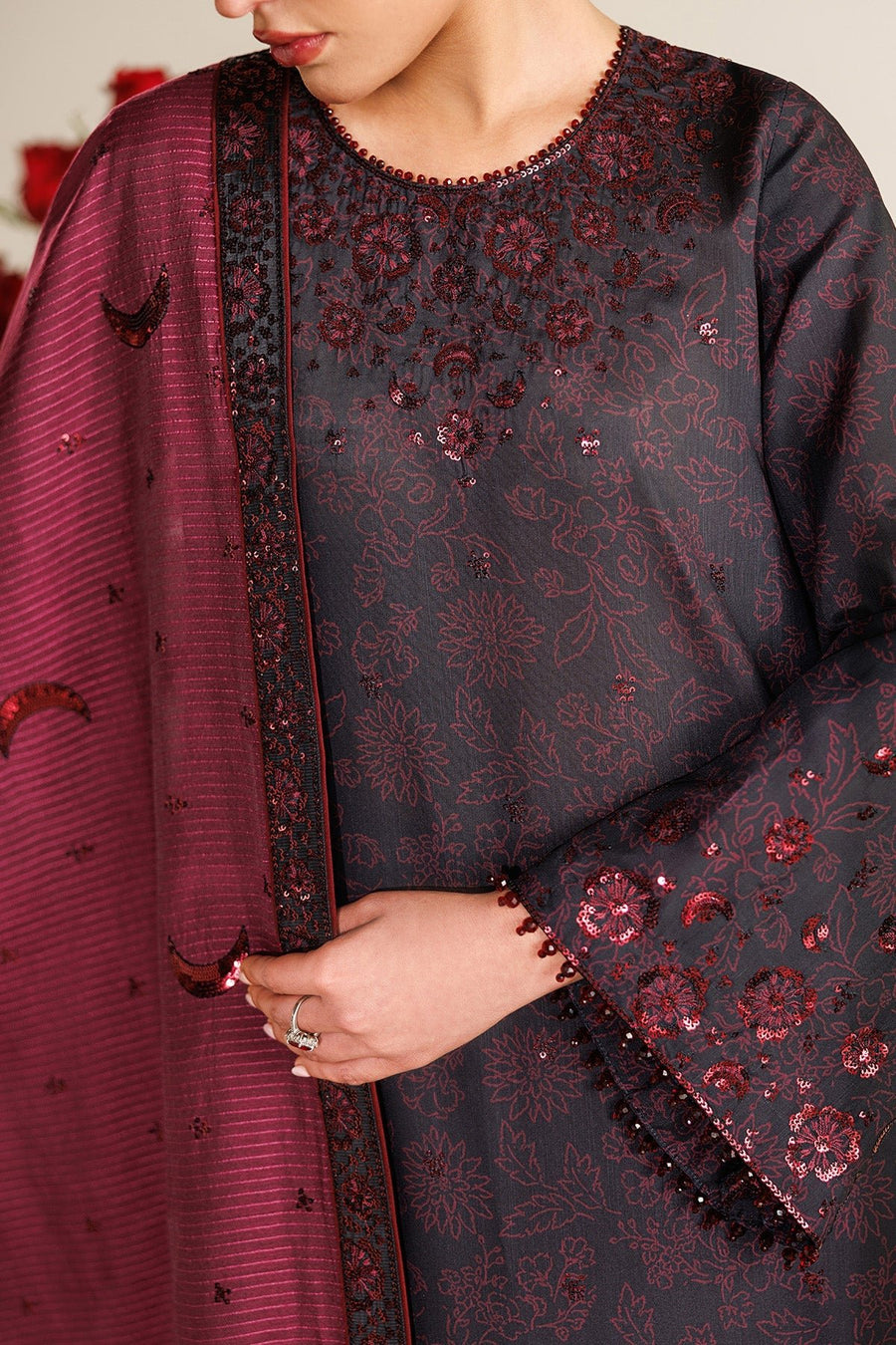 Detail shot of embroidered cuffs on black wide trousers highlighting maroon floral sequin embroidery and delicate bead fringes.