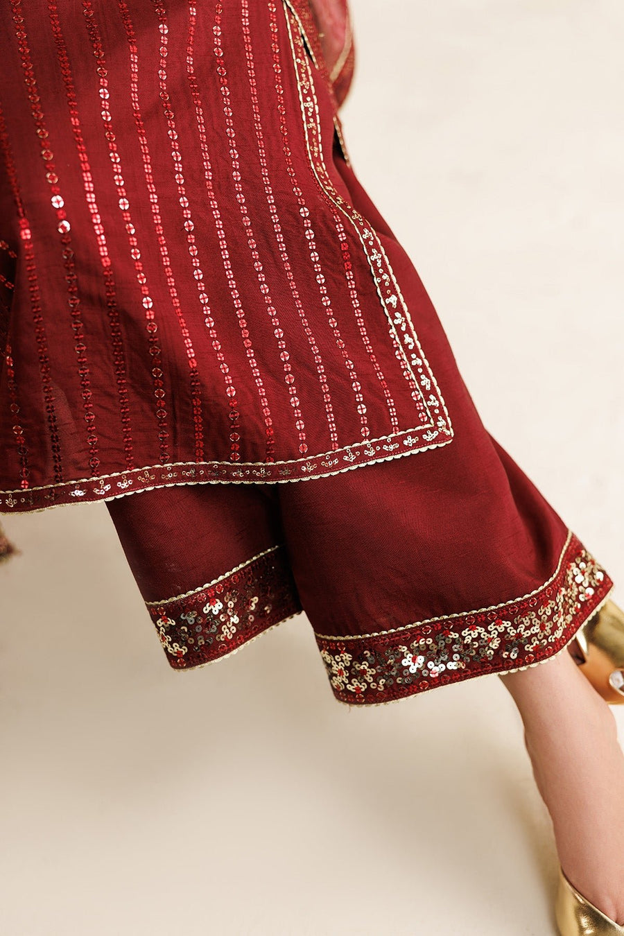 Model standing in elegant maroon embroidered suit with matching ornate dupatta over both shoulders