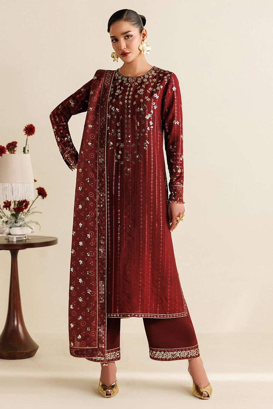 Close-up showing embroidery and sequin details on the front of maroon suit shirt and sleeves