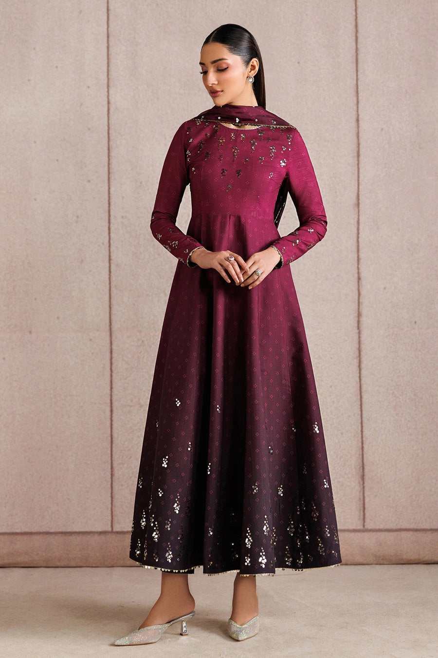 Front view of woman standing in embroidered deep magenta Anarkali suit with flowy skirt and matching dupatta draped on shoulders