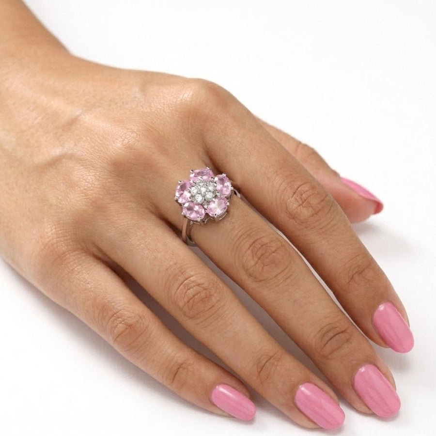 The pink floral ring worn on a woman's hand with matching pink nail polish, showing scale and wearability.