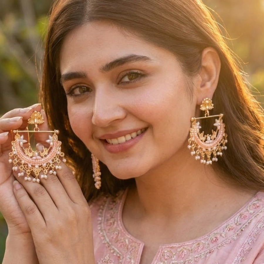 Woman wearing mint green stone gold-plated pearl jhumka earrings in traditional teal attire