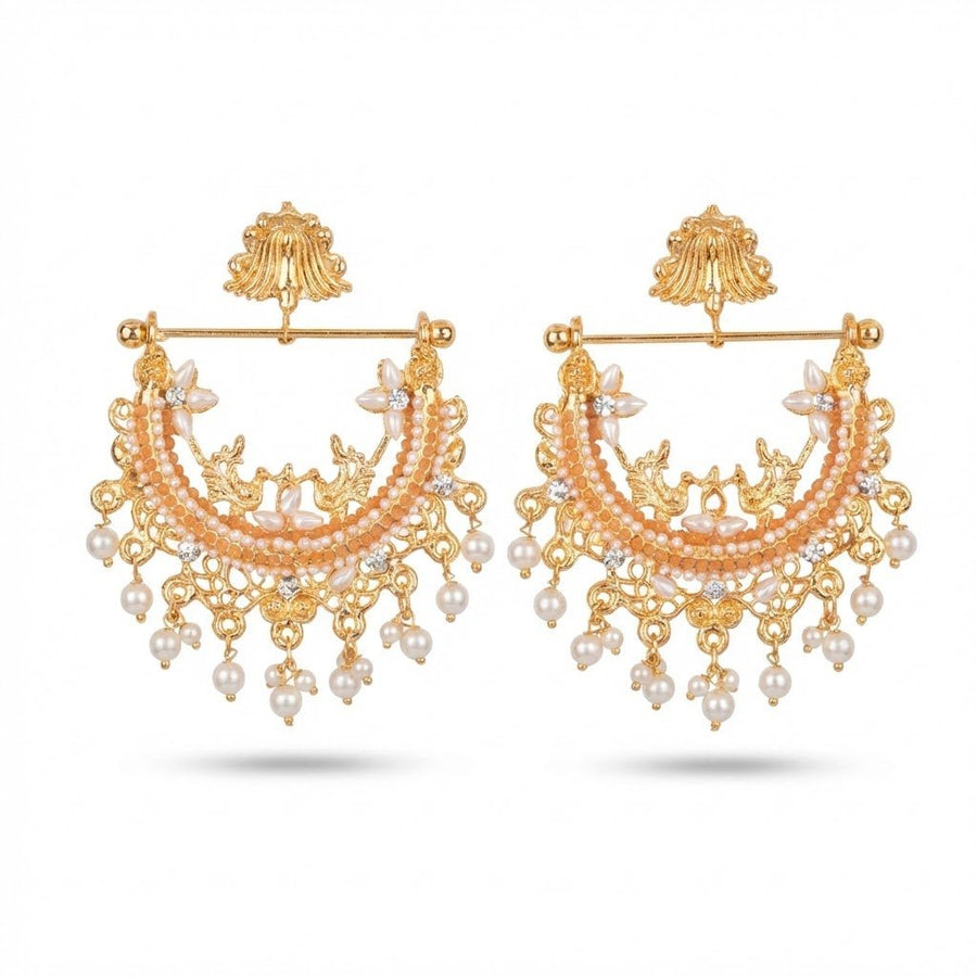 Pair of gold-plated jhumka earrings with peach stones and pearl hangings on cream background