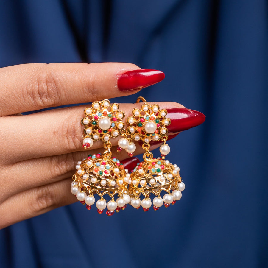 Elegant Pearl Chandbali earrings displayed on hand, showcasing floral stone settings and hanging pearl jhumkas