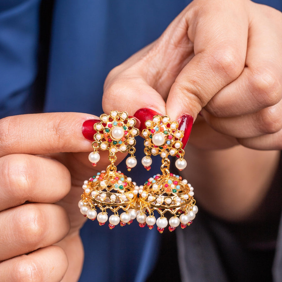 Pearl Chandbali earrings held by fingers, highlighting craftsmanship and pearl embellishments