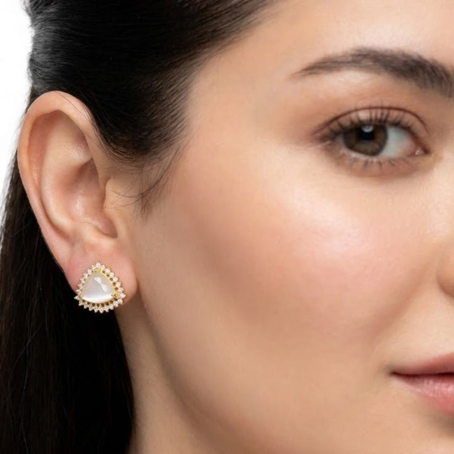 Model wearing milky white trillion cut gemstone halo stud earring showing side profile of ear