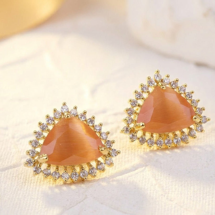 Amber trillion cut gemstone halo stud earrings worn in pierced ear close view