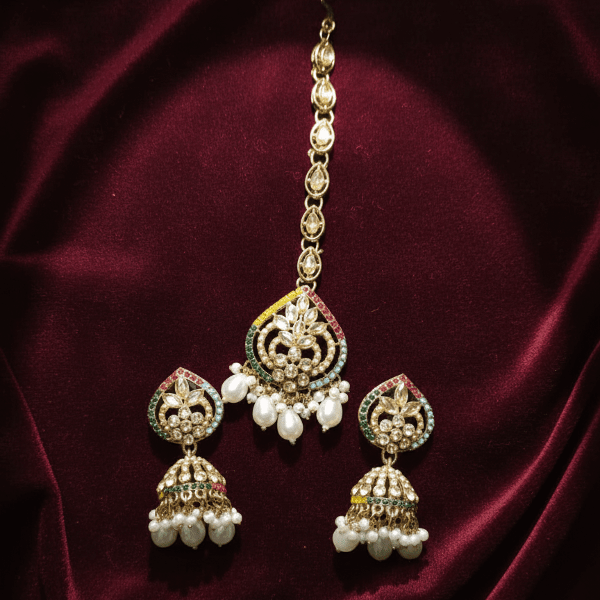 Majesty Pearl Drop set placed on deep maroon fabric highlighting gold tones and pearl details