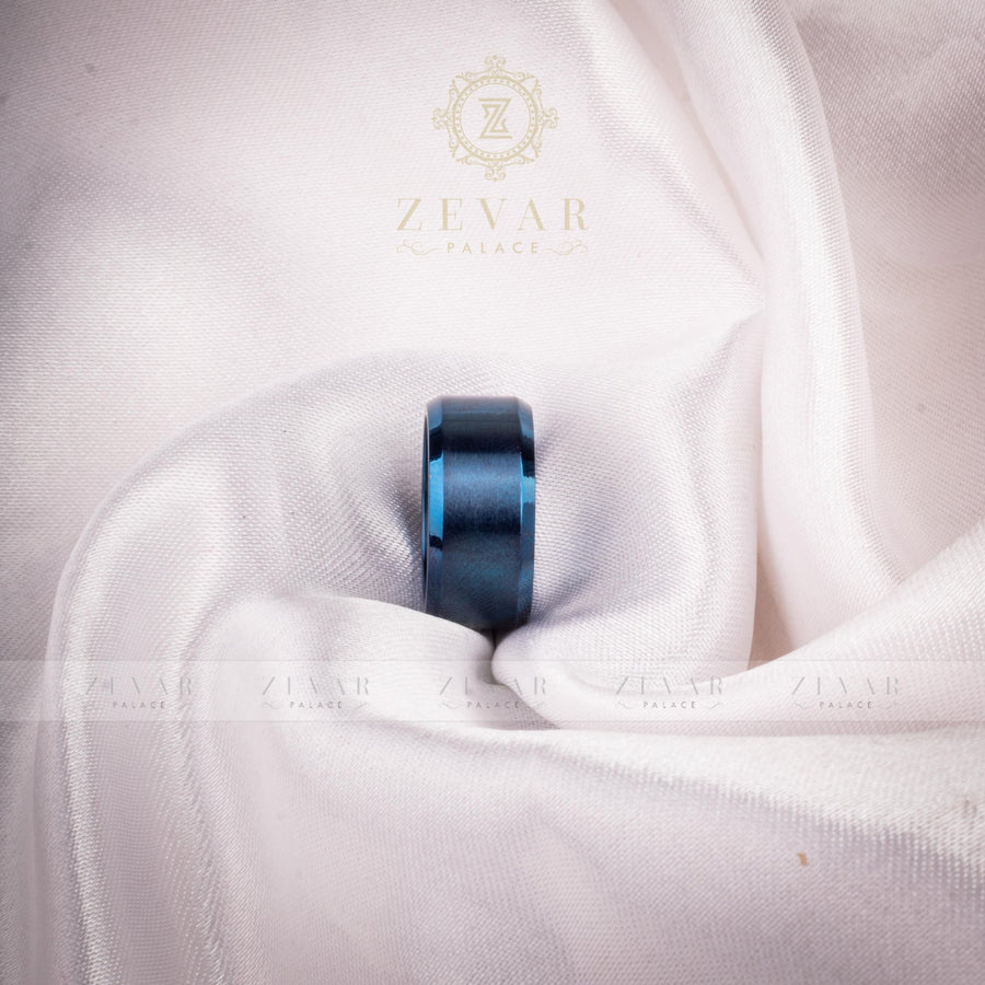 Blue brushed titanium ring with polished beveled edges resting on white satin fabric with Zevar Palace logo