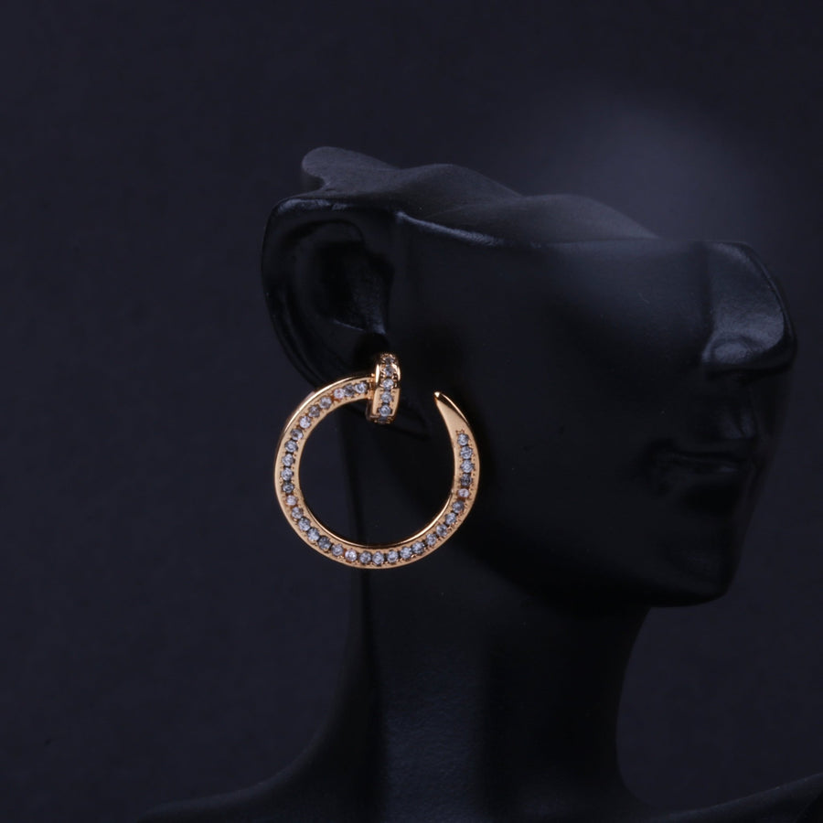 Silver-tone rhinestone circle hoop earring worn on black mannequin ear against dark background