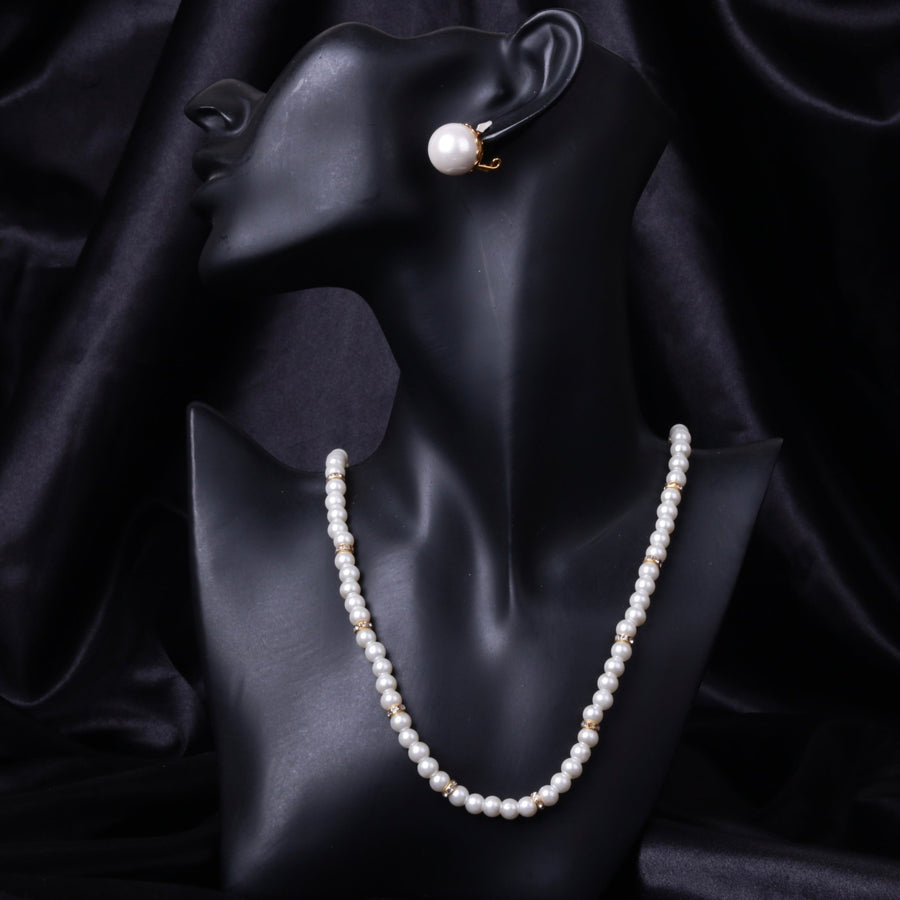 Black mannequin bust showing side view of the white pearl necklace with gold accents and matching clip-on mother of pearl earring.