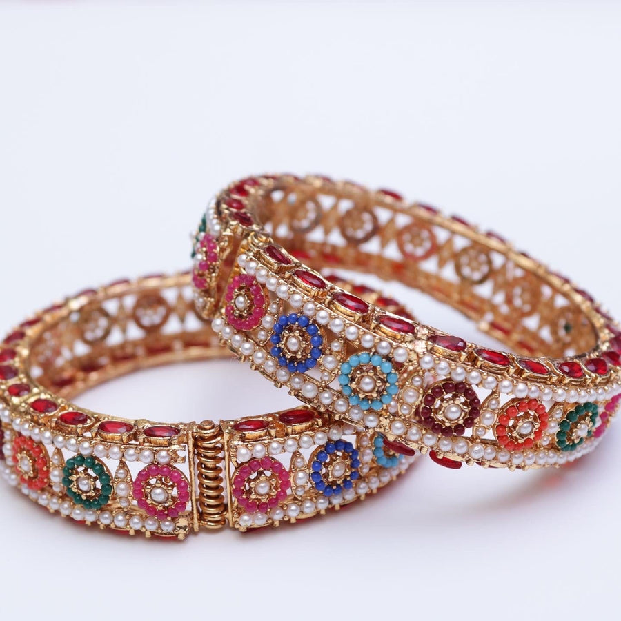 Pair of ornate gold-plated bangles decorated with multicolored stones and pearl accents showcasing intricate floral patterns