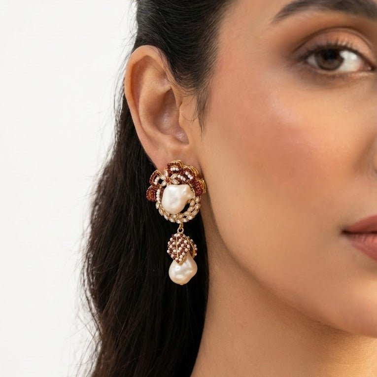 Model wearing emerald green drop earring with white pearl and crystal leaves