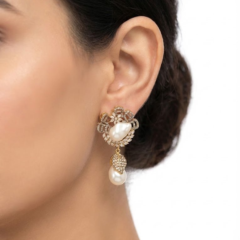 Model wearing gold-plated white pearl drop earring with intricate crystal detailing