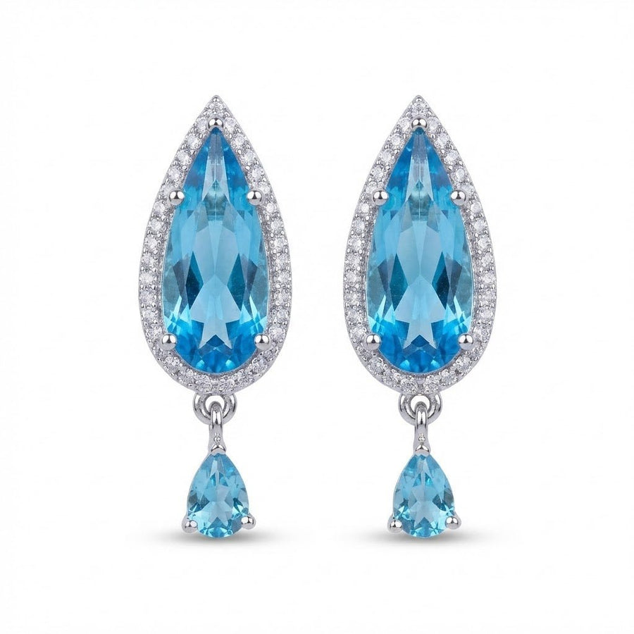 Close-up of pale aqua crystal earrings held in hand catching light sparkle