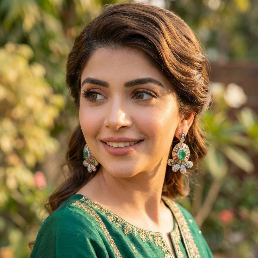 Model in green outfit wearing emerald green center floral gemstone stud earrings styled with natural waves