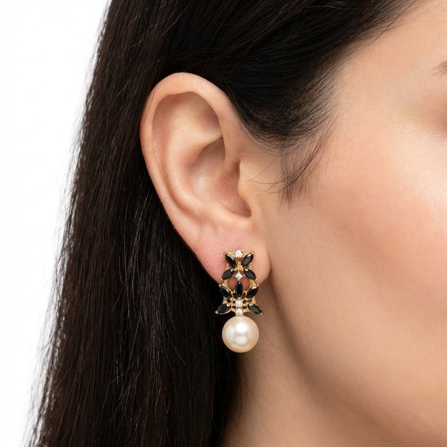Close-up of person wearing black stone pearl drop earring showing elegant design