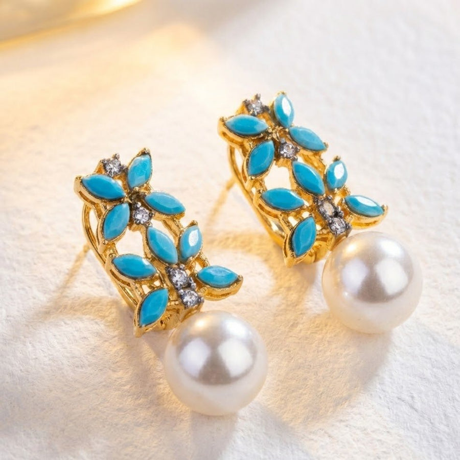 Large white pearl drops with multicolor marquise stones on display against neutral backdrop
