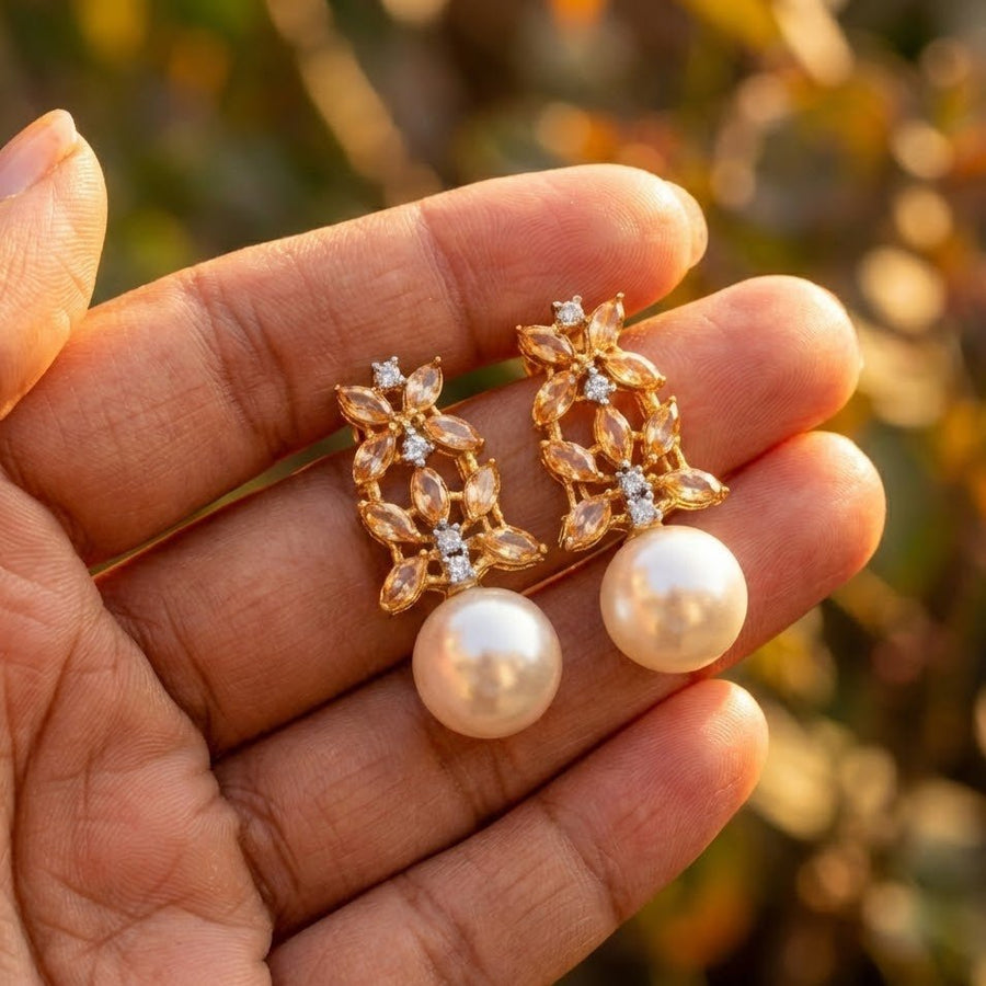 Soft natural golden hour lighting on pink pearls drop earrings held in hand