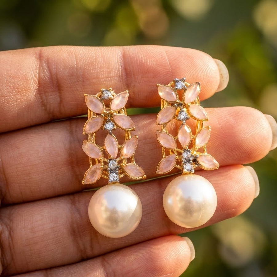 Neutral light image focusing on pearl drop earrings with combined colored marquise stones