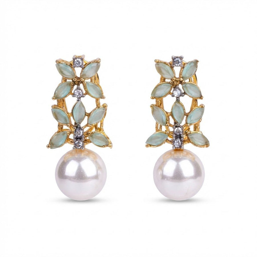 Pink gemstone and pearl drop earrings on a beige textured surface