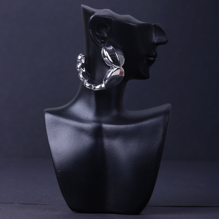 Silver chunky hoop earring on black mannequin bust highlighting smooth curves and polished finish