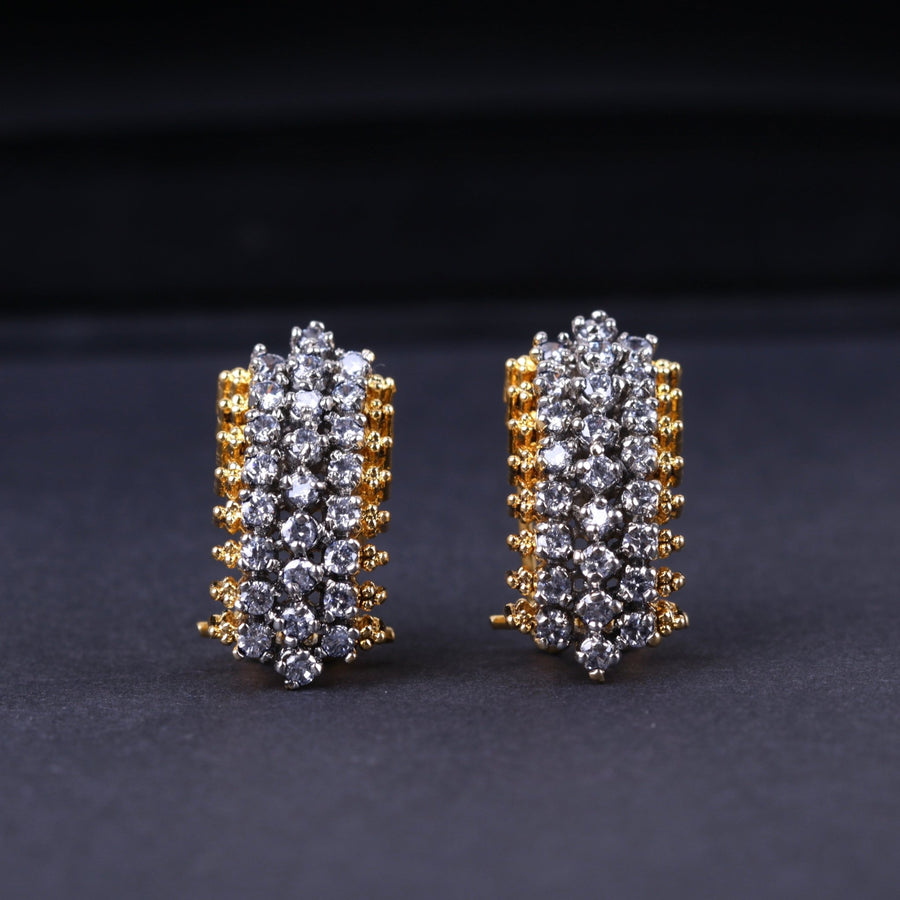 Front view of the gold-plated zirconia stud earrings displaying the brilliant aligned rows of stones on a textured dark surface