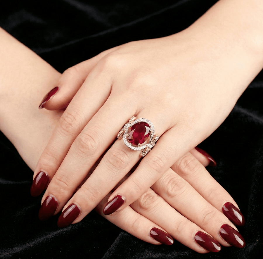 Close-up of oval red gemstone semi-precious ring with bow and pavé cubic zirconia on a woman’s hand