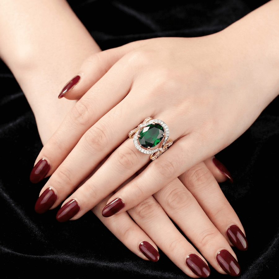 Yellow oval semi-precious gemstone ring with bow-shaped cubic zirconia accents on a woman’s hand with dark red nails