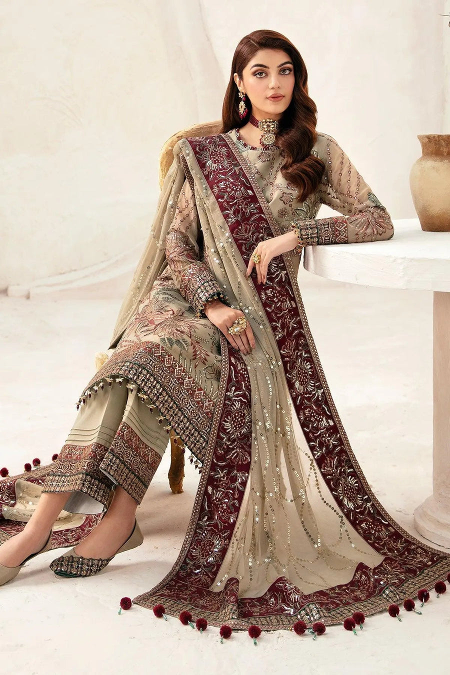 Side view of woman standing in embroidered chiffon shirt with matching trousers and dupatta