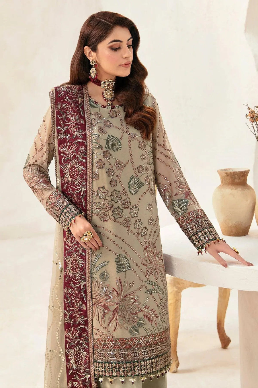 Detailed view of embroidered sleeves and cuffs on chiffon shirt with tassel finish on dupatta