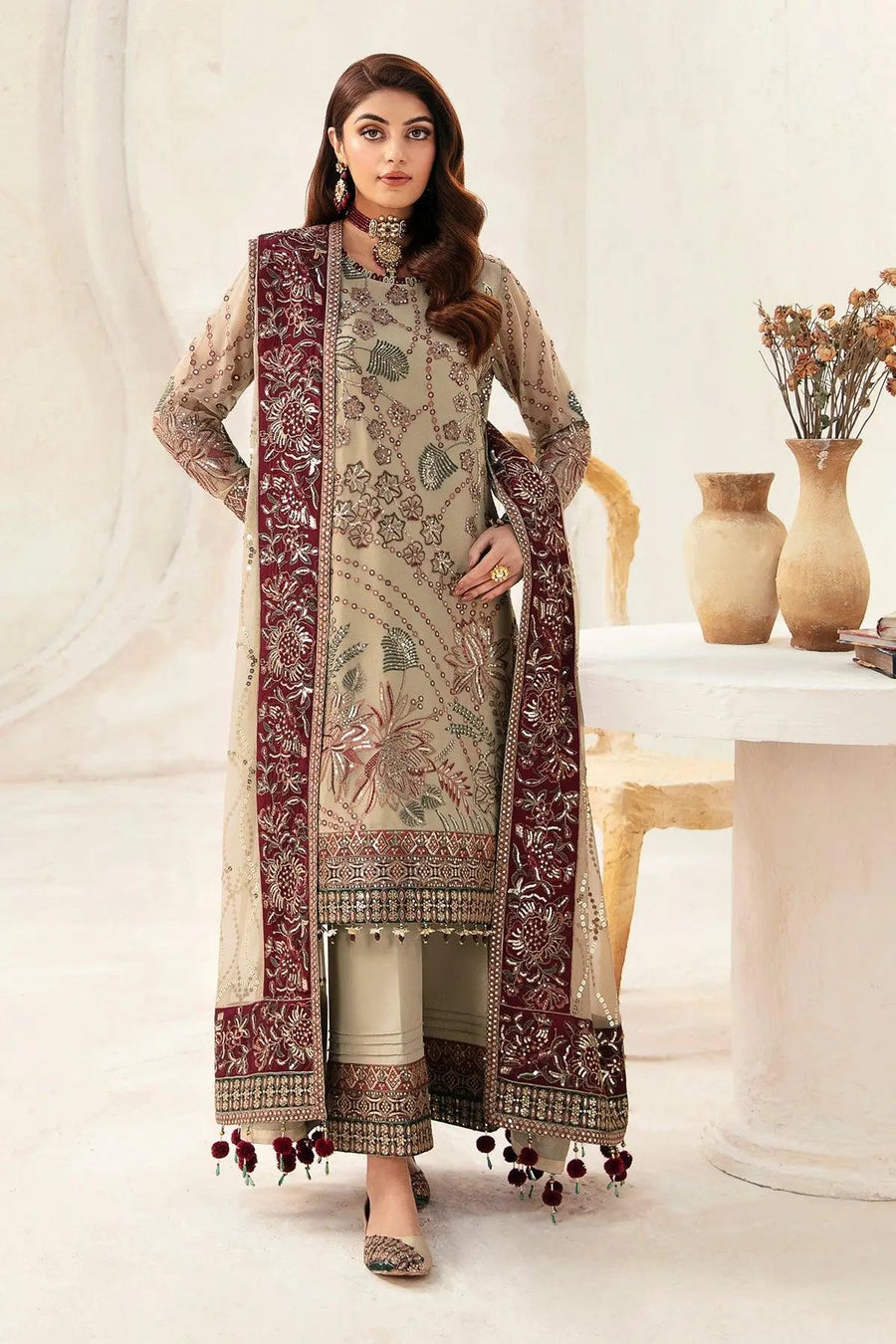 Front view of woman wearing embroidered chiffon formal suit with maroon bordered dupatta